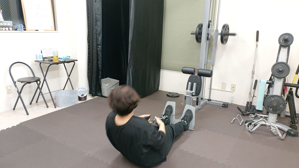 ジムのマットスペースで体幹トレーニングを行うお客様