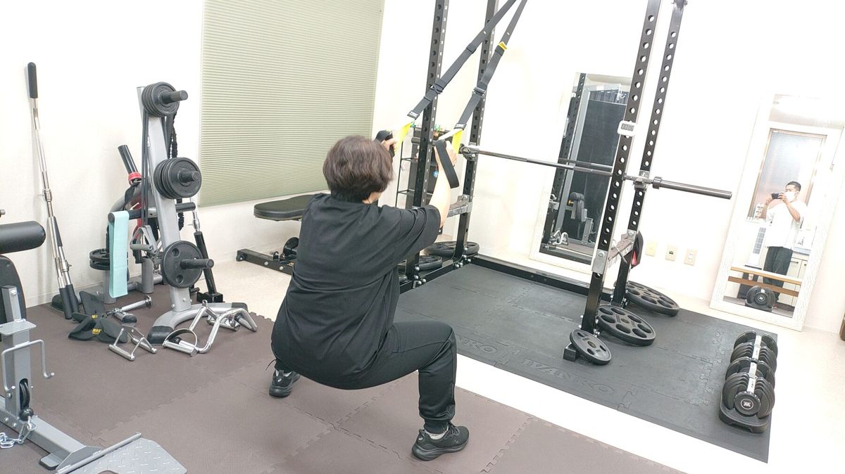 トレーナーが見守る中でスクワットを行うお客様