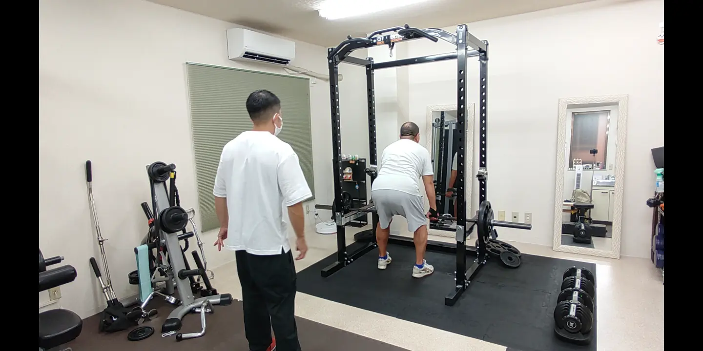トレーナーが見守る中でバーベルローを行うお客様