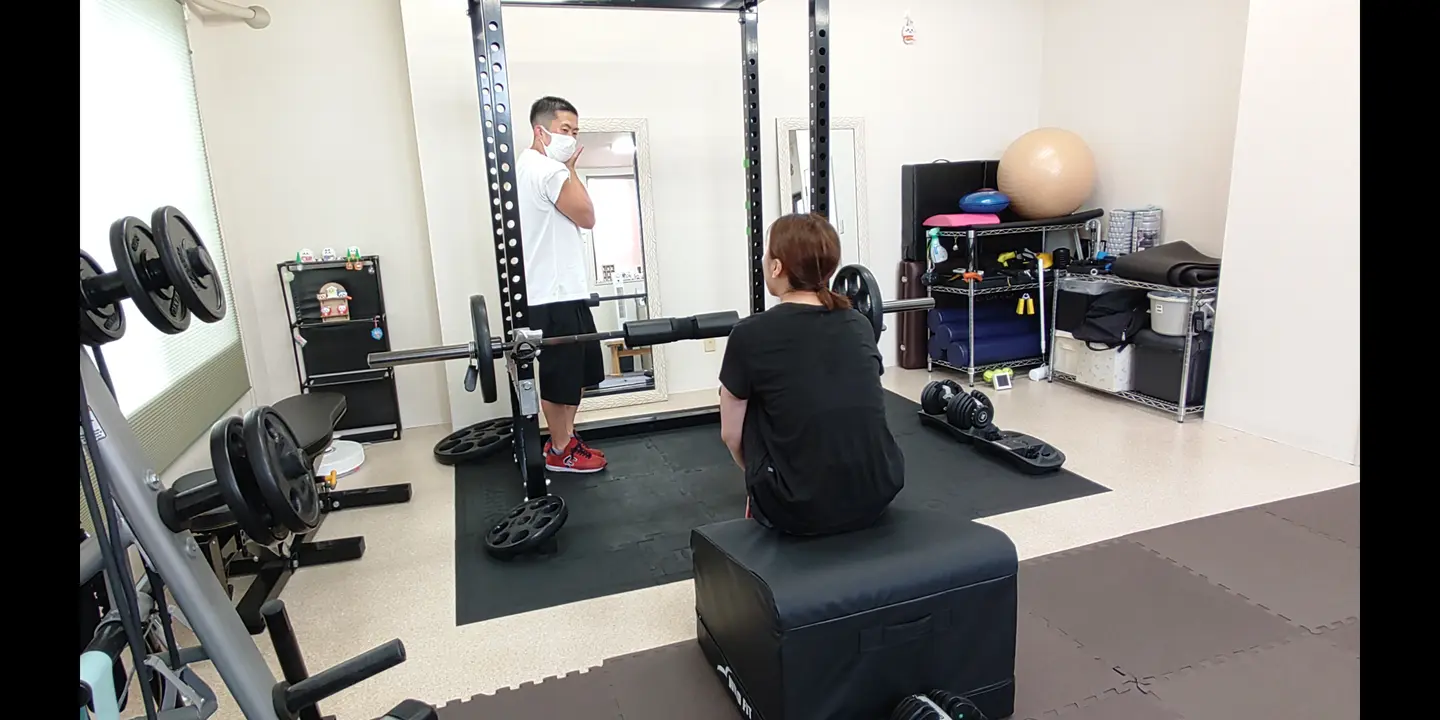 ベンチでのトレーニング後にトレーナーと動きを振り返る様子