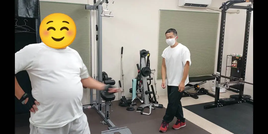 トレーナーが見守る中でダンベルカールを行うお客様