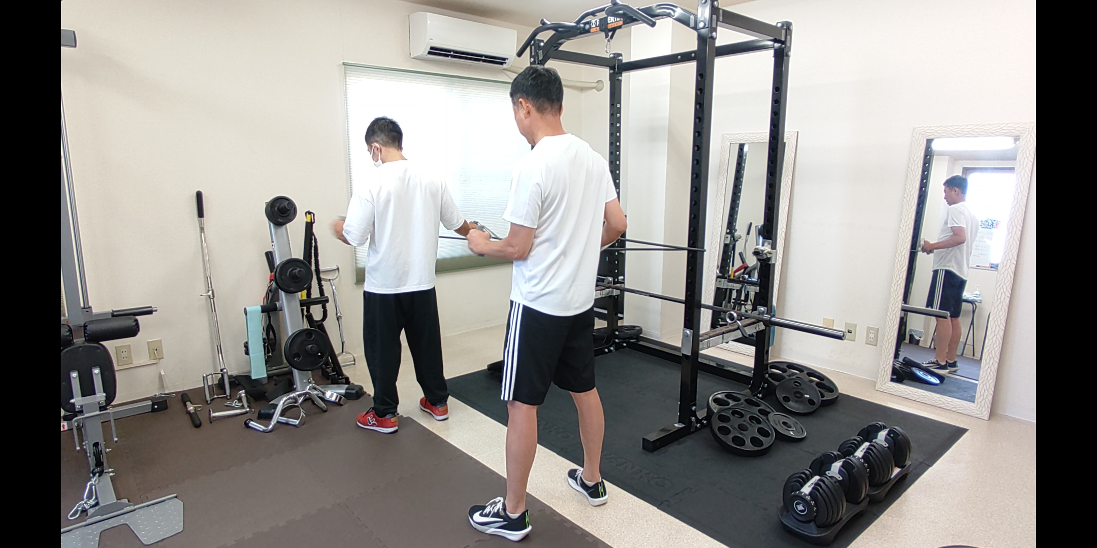 2人のお客様がトレーナーの指導を受けながらバンドトレーニングを行う様子